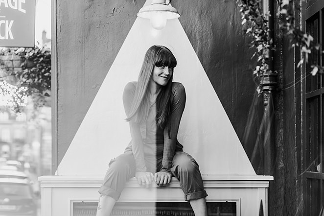 headshot photographer edinburgh takes personal branding images of local small business owner in black and white of woman sitting on a Mantel Piece